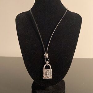 Stigma necklace with black cord and silver tone cross pendant